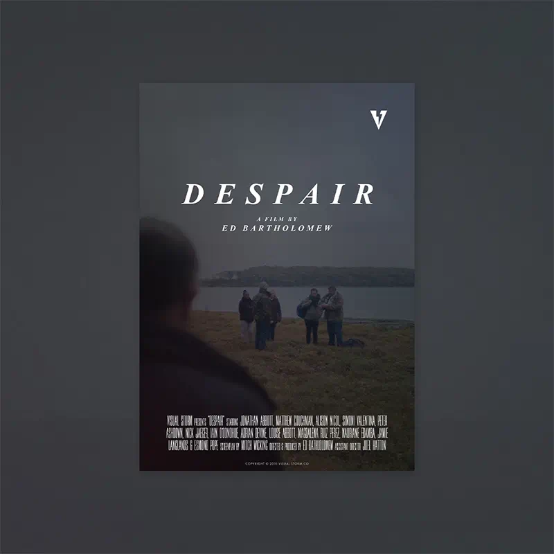 A promotional poster for the short film ‘Despair’. The back of a man is seen looking forward to the beach with immigrants arriving on a gloomy autumn day