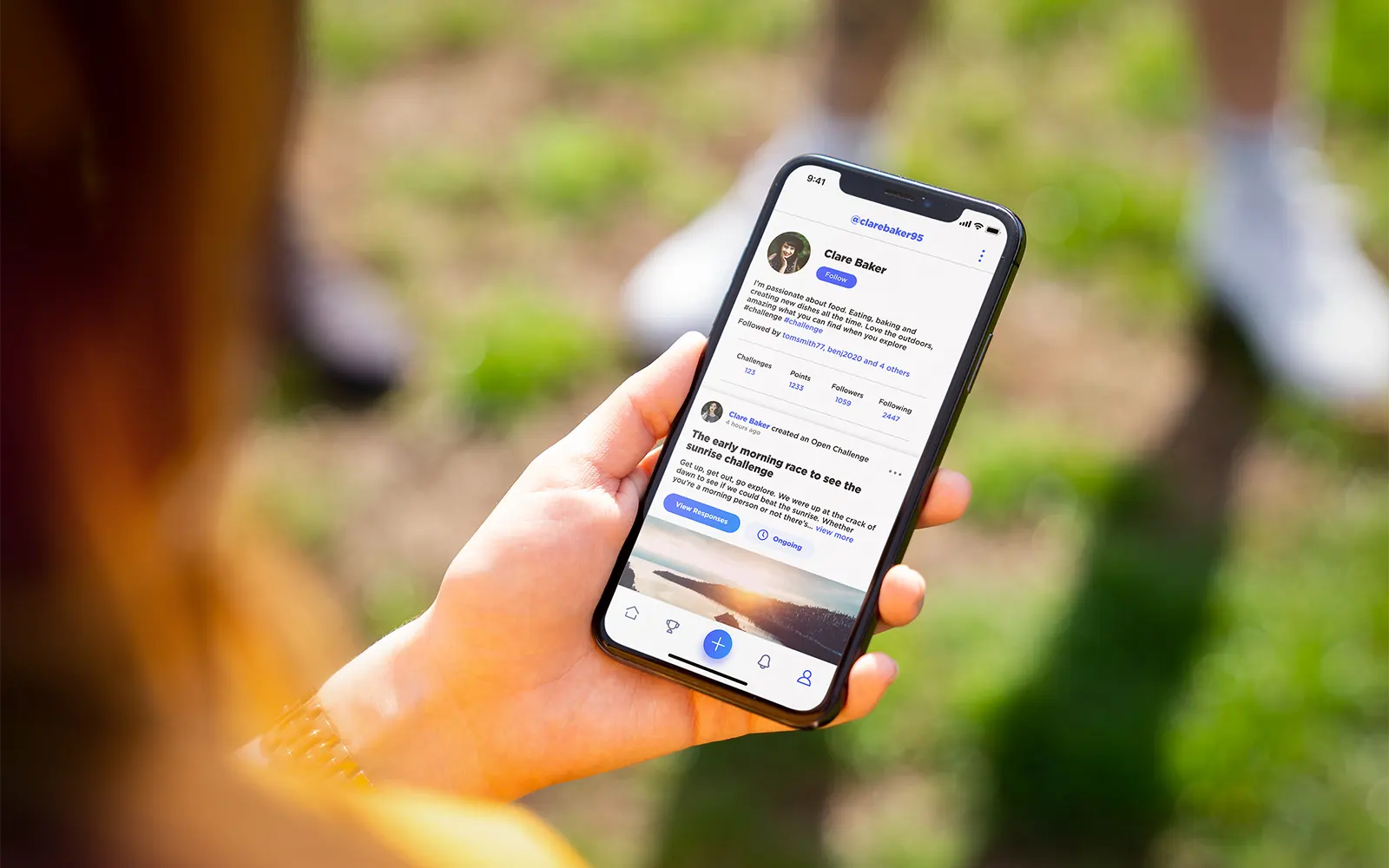 A close up of a smart phone showing the profile page from the Challenge Social app