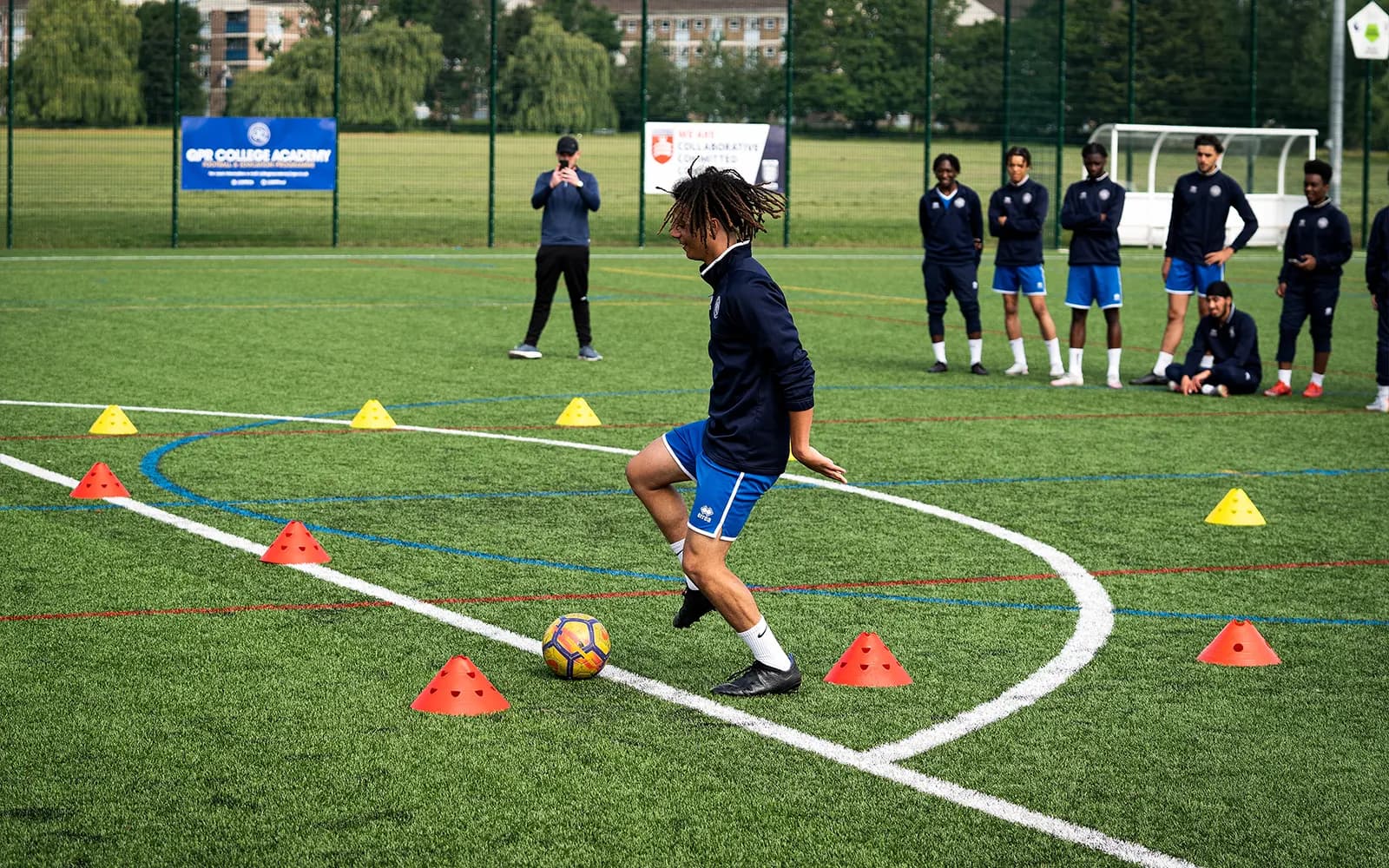 An action shot of a teenage boy during a football training session at a football pitch