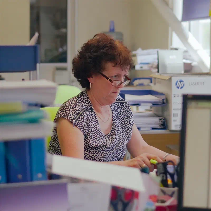 Middle-aged worker typing at a computer in an office setting, a still from the Bartholomews Specialist Distribution Promotional video