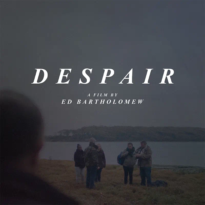 The back of a man is seen looking forward to the beach with immigrants arriving on a gloomy autumn day, introducing ‘Despair’ a short film by Ed Bartholomew