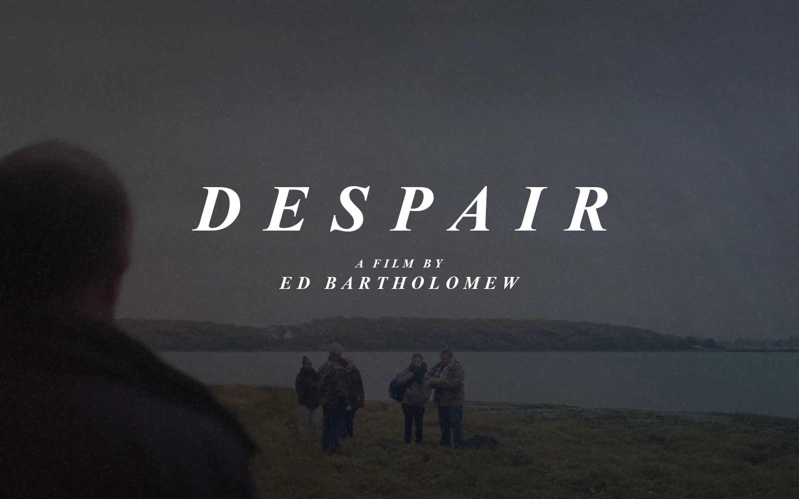 The back of a man is seen looking forward to the beach with immigrants arriving on a gloomy autumn day, introducing ‘Despair’ a short film by Ed Bartholomew
