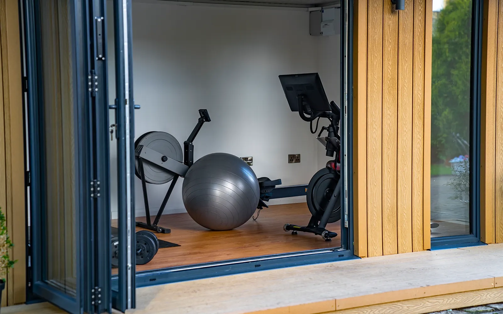 A photo looking into a garden room which has been set up as a home gym