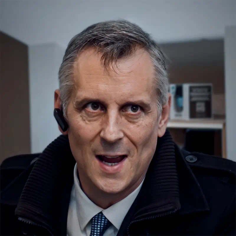 A still from the short film ‘Sub Rosa’ showing a close up of an angry-looking middle-aged businessman wearing a Bluetooth earpiece